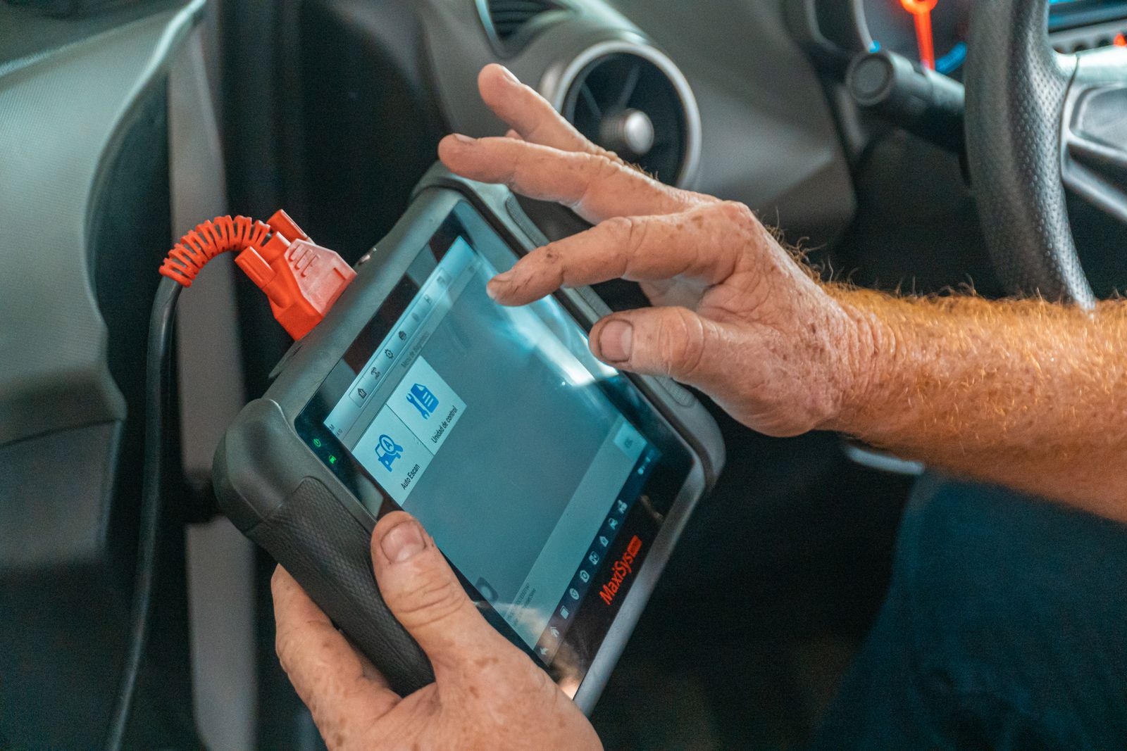 Technician running a computerized diagnostic scan on a vehicle's onboard computer